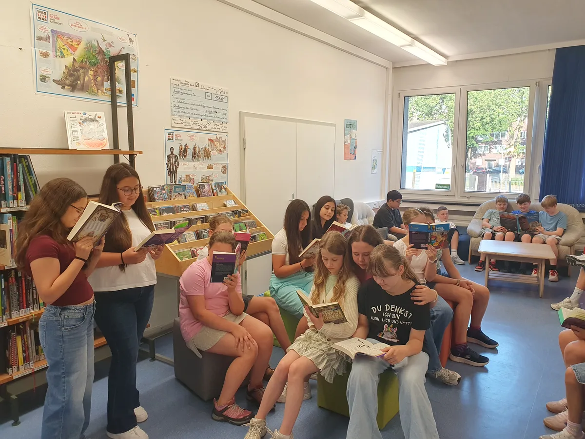 Lesende Schüler:innen auf Sitzwürfeln in der Bücherei