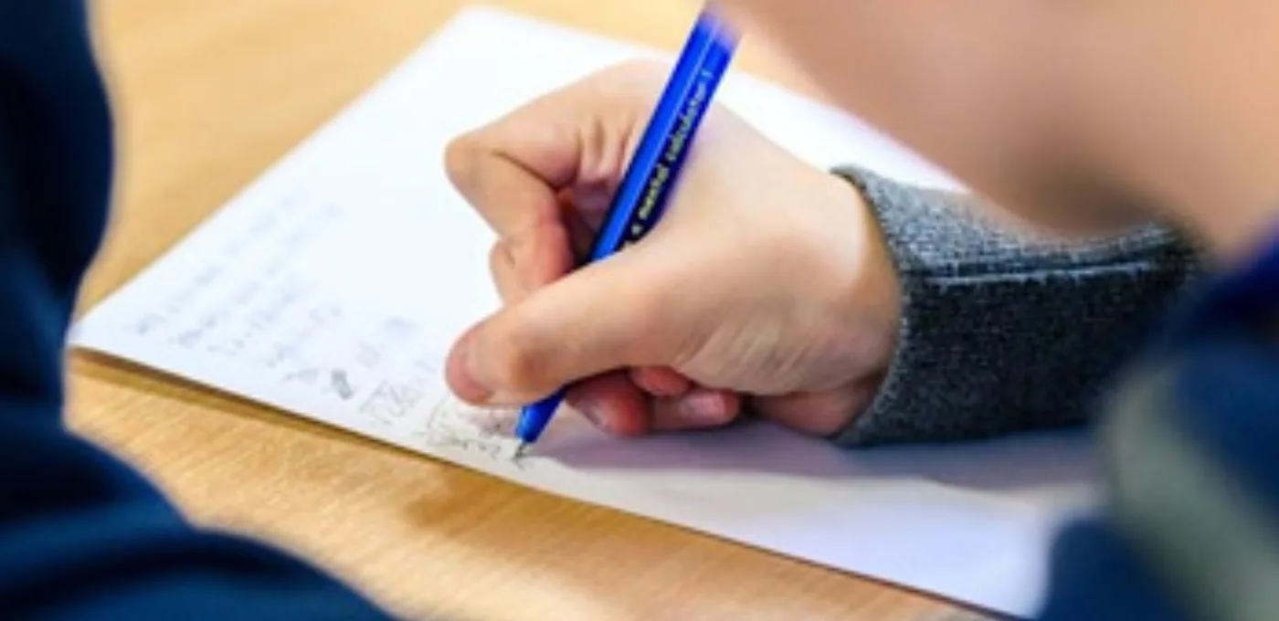 Kind schreibt mit blauem Stift